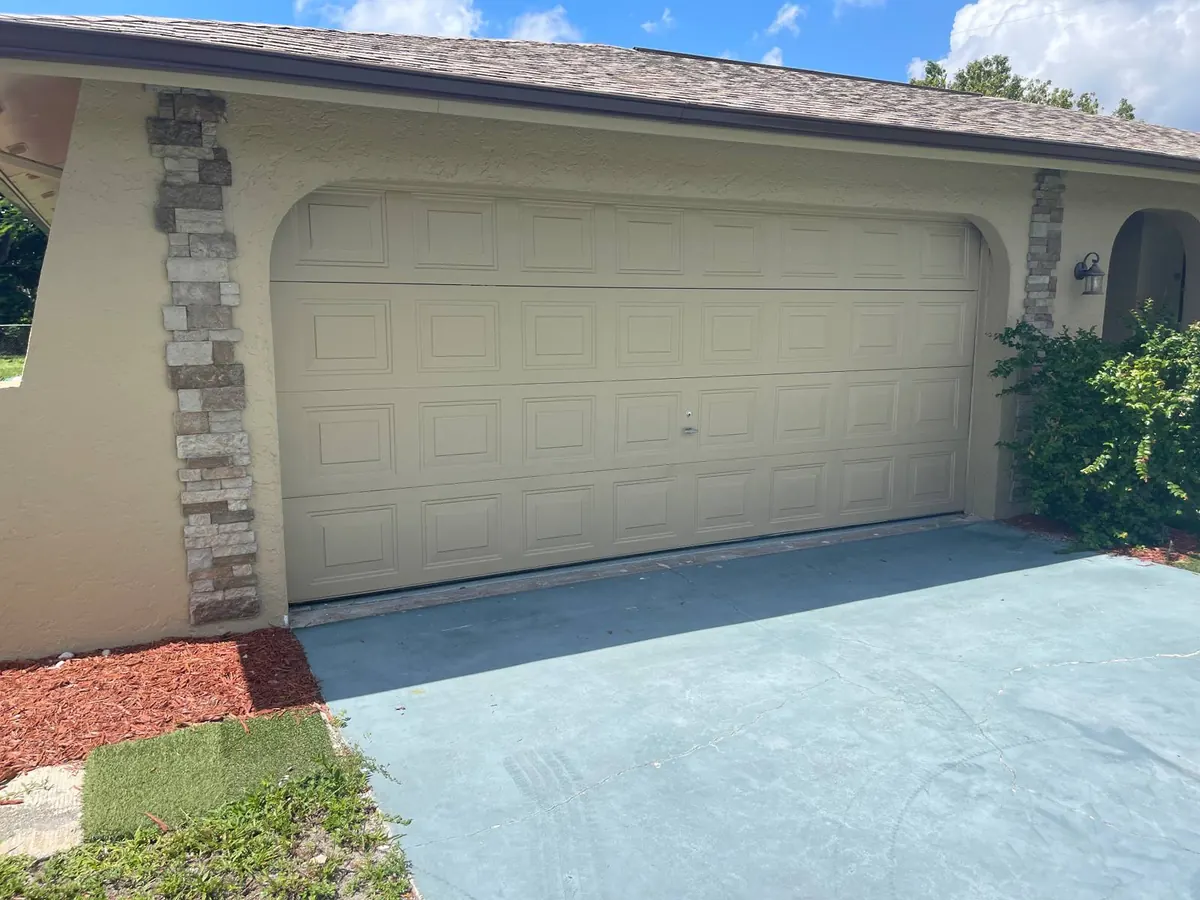 Beige short-panel raised garage door on a stucco home in Englewood serviced by 941-Garage-Door